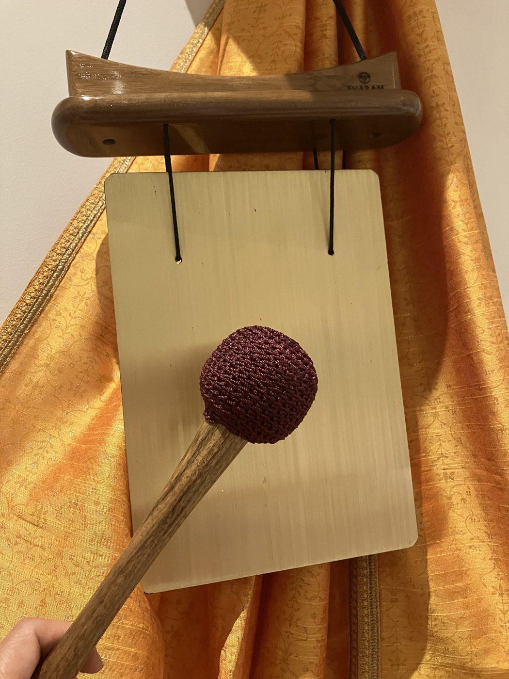 Meditation chime with a wrapped mallet, on golden silk